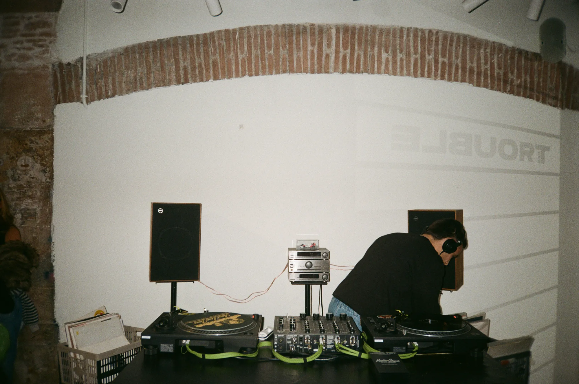 Cabina con dos Technics SL-1210 MK7, la MasterSounds Radius 4V y los Tannoy T-115 sobre soportes, con el DJ mezclando